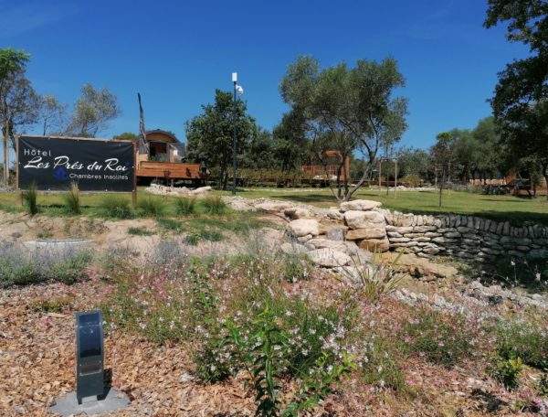 Hôtel insolite Les Prés du Roy, avec chambres entourées de verdure et de fleurs.