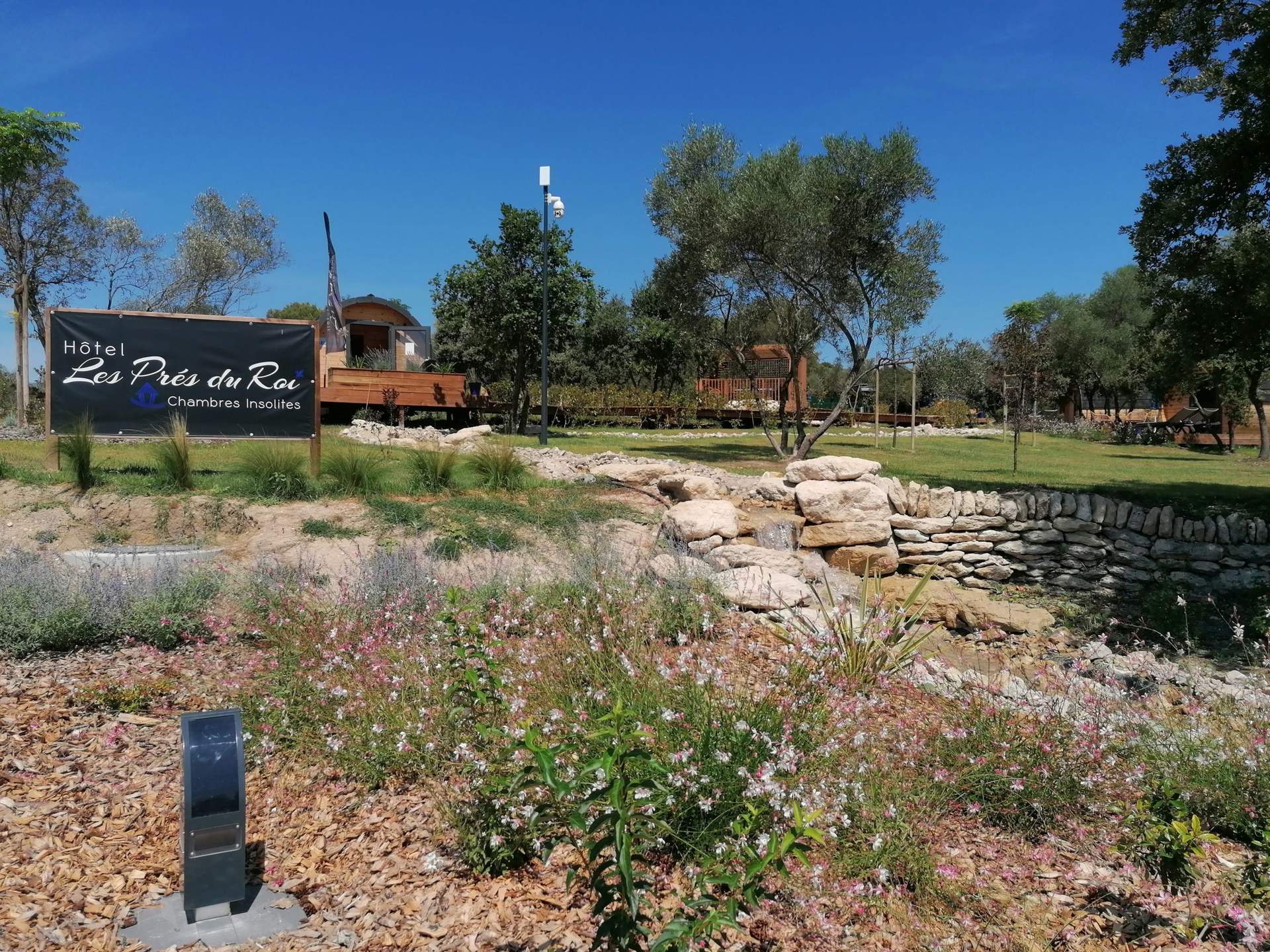 Hôtel insolite Les Prés du Roy, avec chambres entourées de verdure et de fleurs.