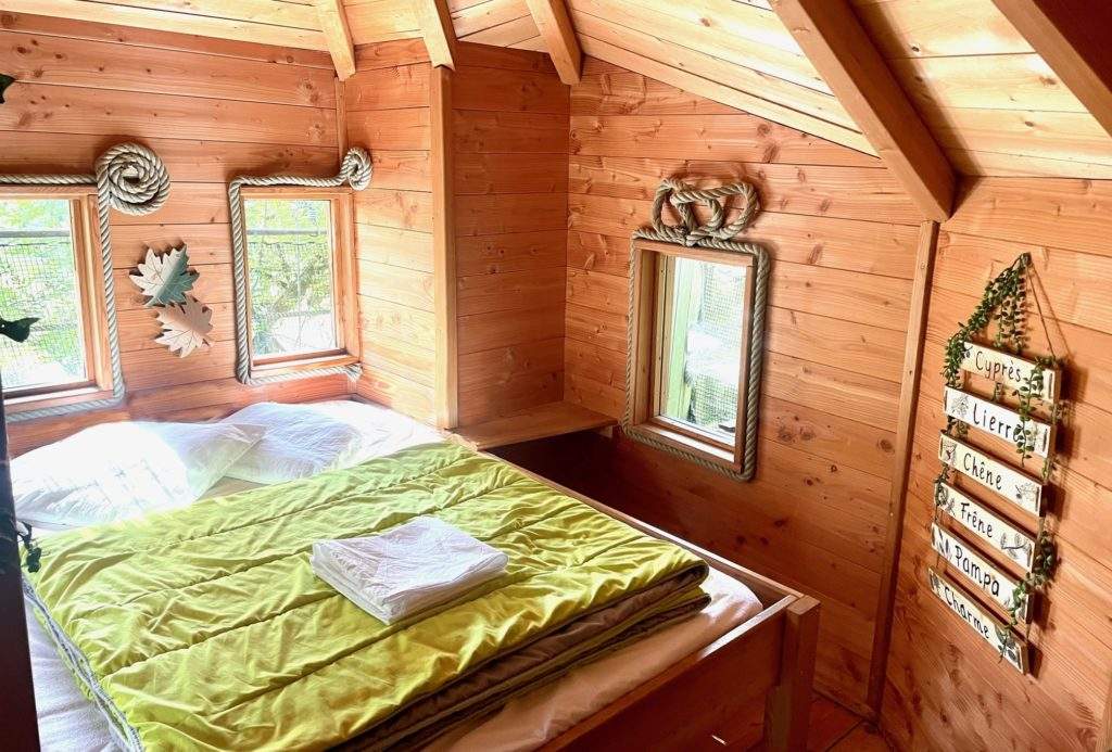 feuilles2 Cabane en bois chaleureuse avec un lit douillet et des fenêtres lumineuses.