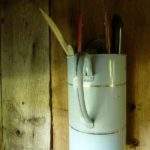 Hébergement rural avec un pot en métal accroché au mur, décor vintage charmant.