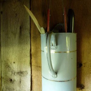 Hébergement rural avec un pot en métal accroché au mur, décor vintage charmant.