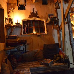 Cabane en bois chaleureuse avec un coin salon confortable et des lumières douces.