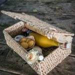 Panier en osier rempli de douceurs et boissons, parfait pour un séjour romantique.