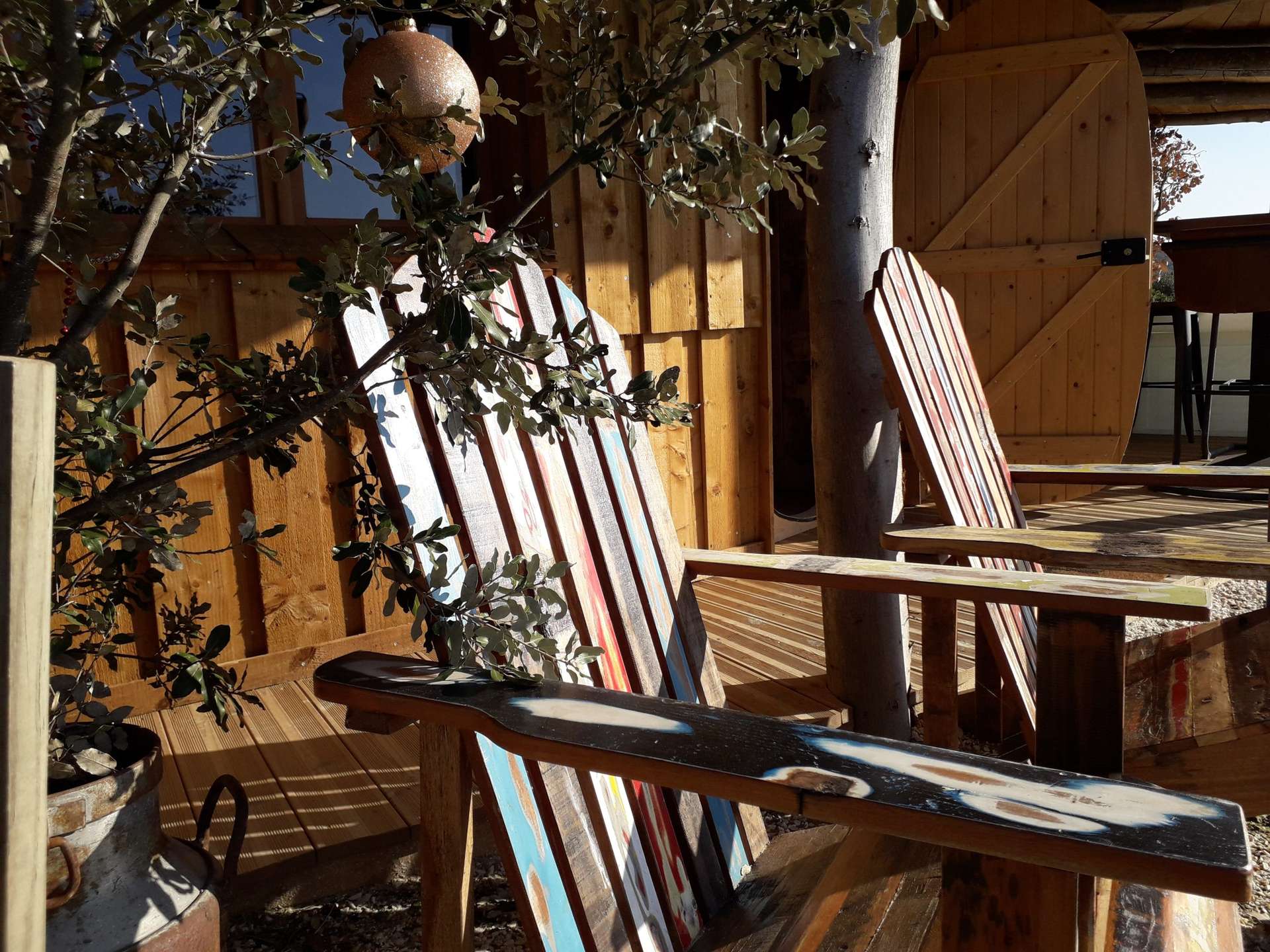 20191231_113542 Hébergement insolite en bois avec chaises colorées et ambiance chaleureuse à Languedoc-Roussillon.