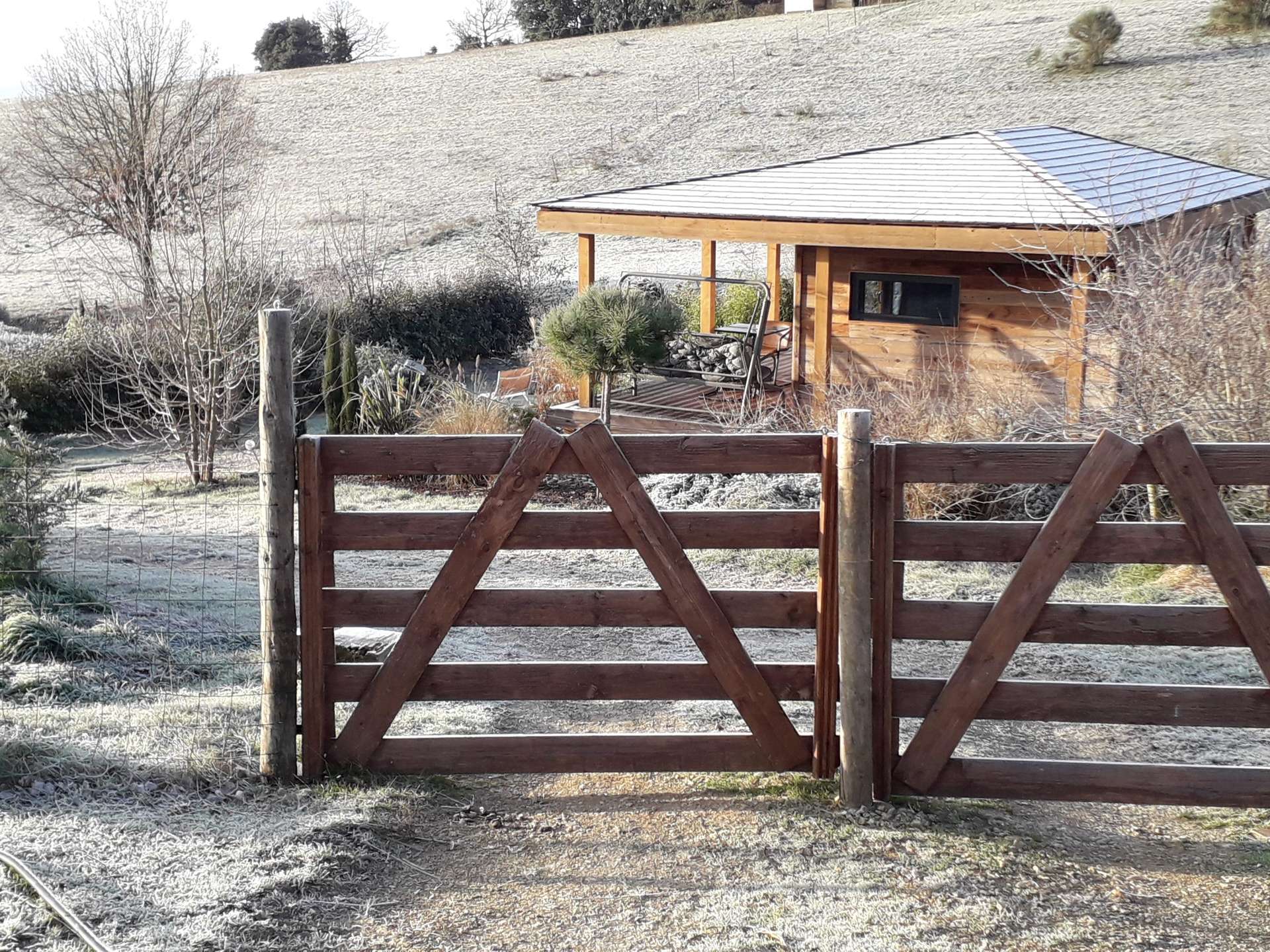 20210107_093634 Cabane en bois avec terrasse, entourée de nature et de givre matinal.