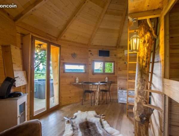 Cabane en bois chaleureuse avec vue panoramique et coin salon confortable.