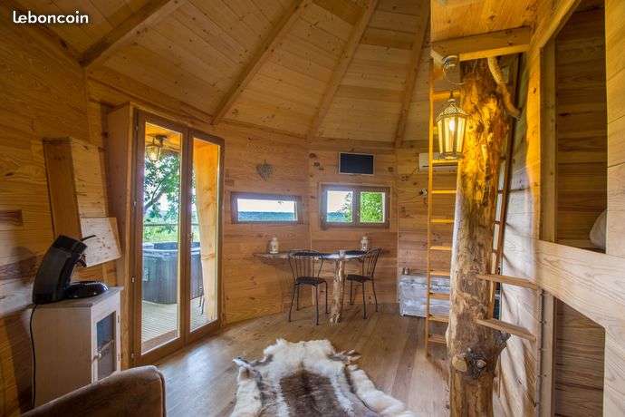 Cabane en bois chaleureuse avec vue panoramique et coin salon confortable.