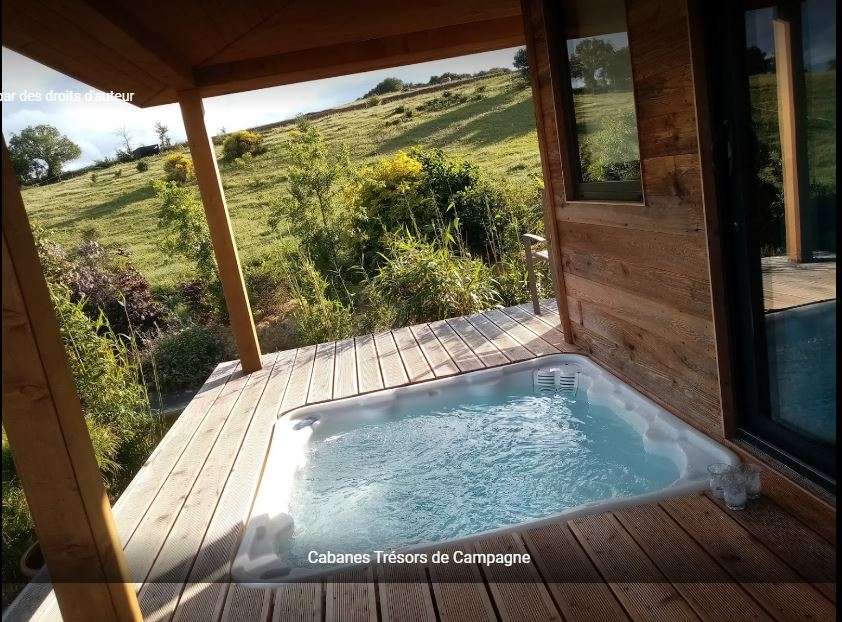 Spa privatif Cabane en bois avec jacuzzi, vue sur la nature verdoyante en Languedoc-Roussillon.