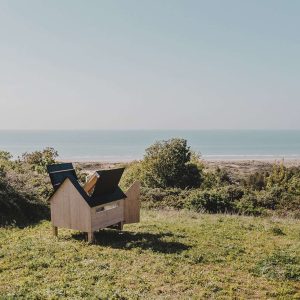Cabane en bois avec vue panoramique sur la mer et la nature environnante.