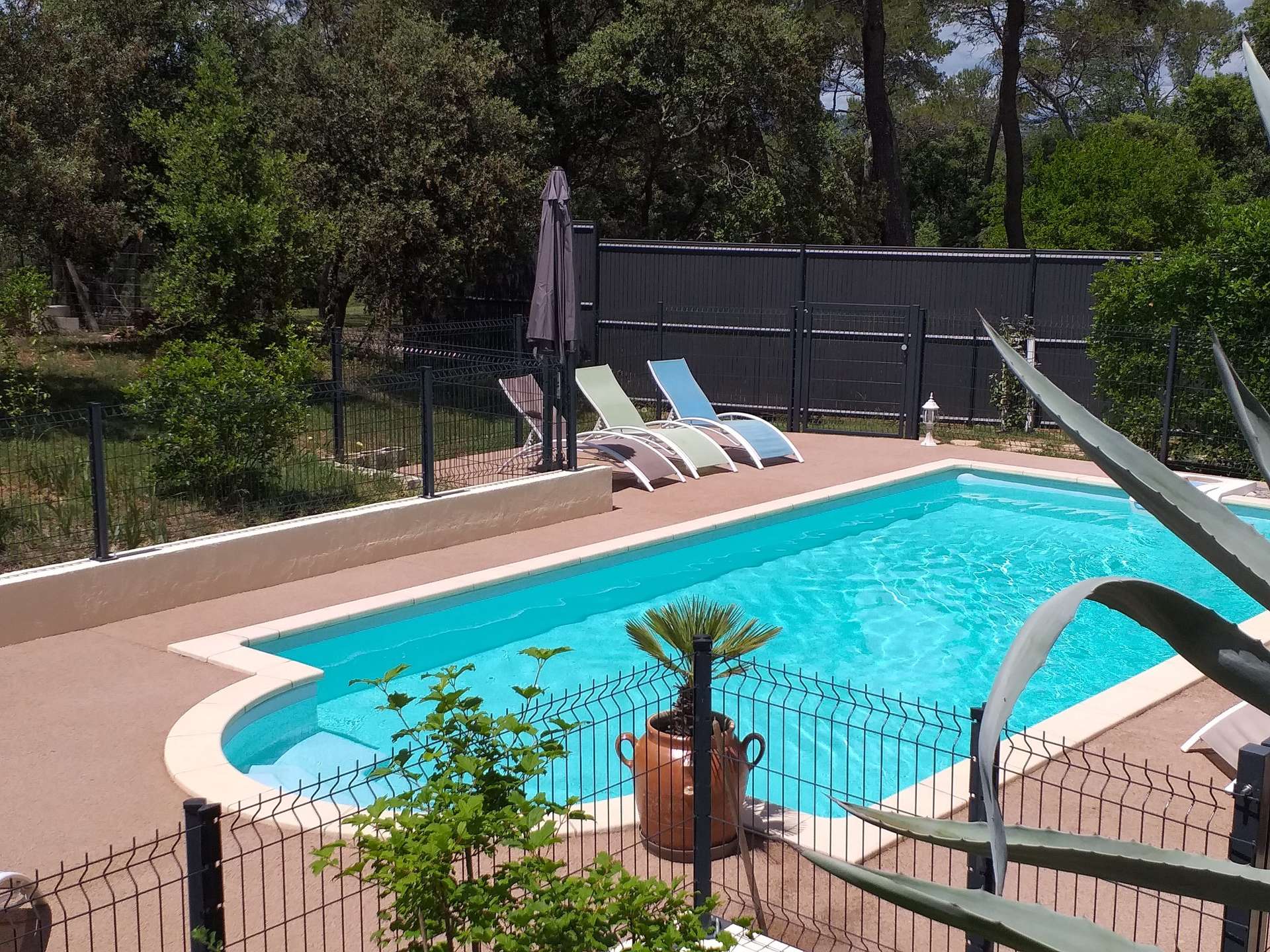 piscine - gite roulotte entre vignes et oliviers - cevennes - gard Hébergement insolite avec piscine, entouré de verdure et chaises longues relaxantes.