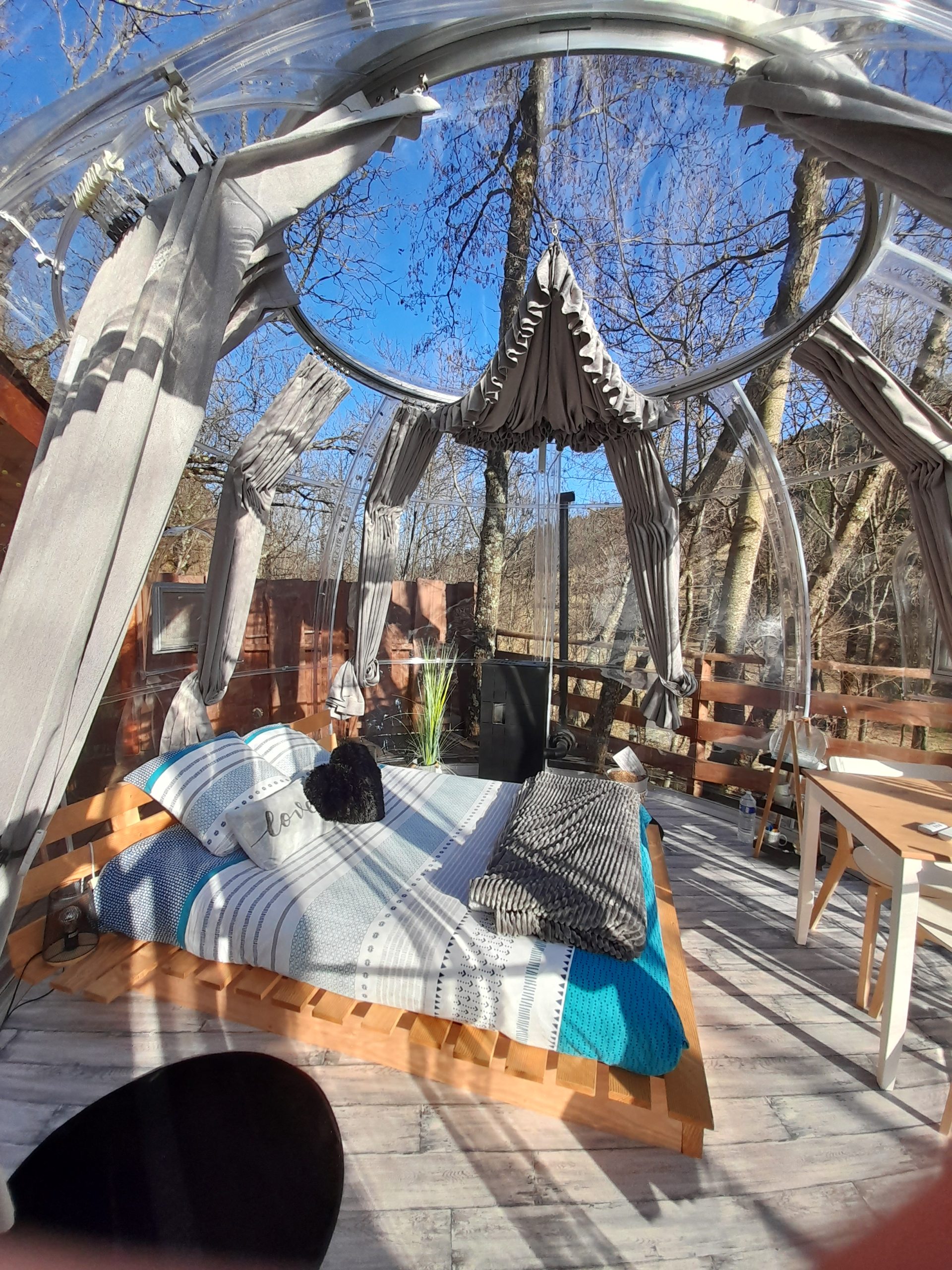 20220210_152912 Hébergement insolite en bulle transparente, lit douillet sous un ciel dégagé.