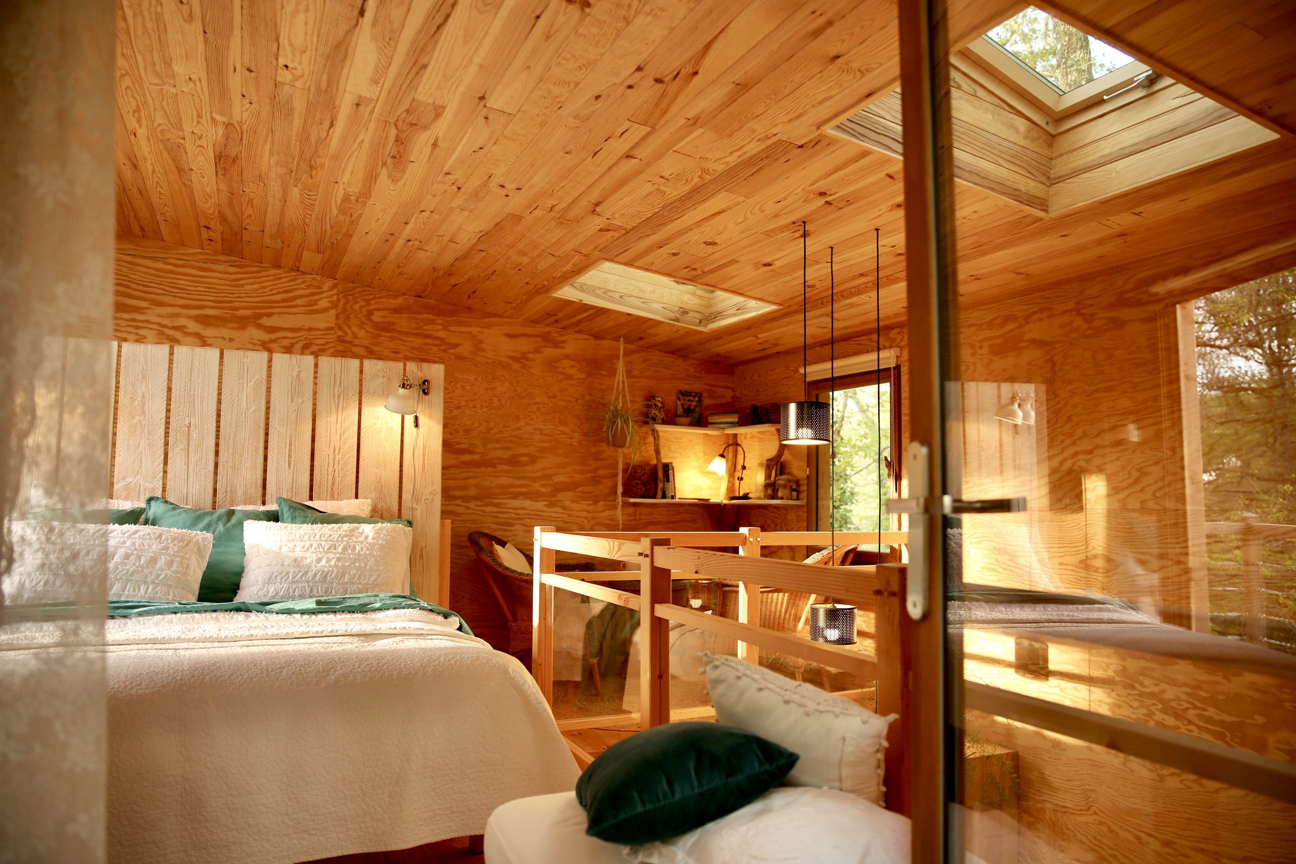 Cabane en bois avec un intérieur chaleureux et lumineux, vue sur la nature.