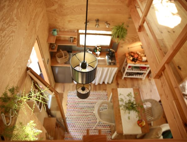 Cabane en bois avec une décoration chaleureuse et un éclairage suspendu.