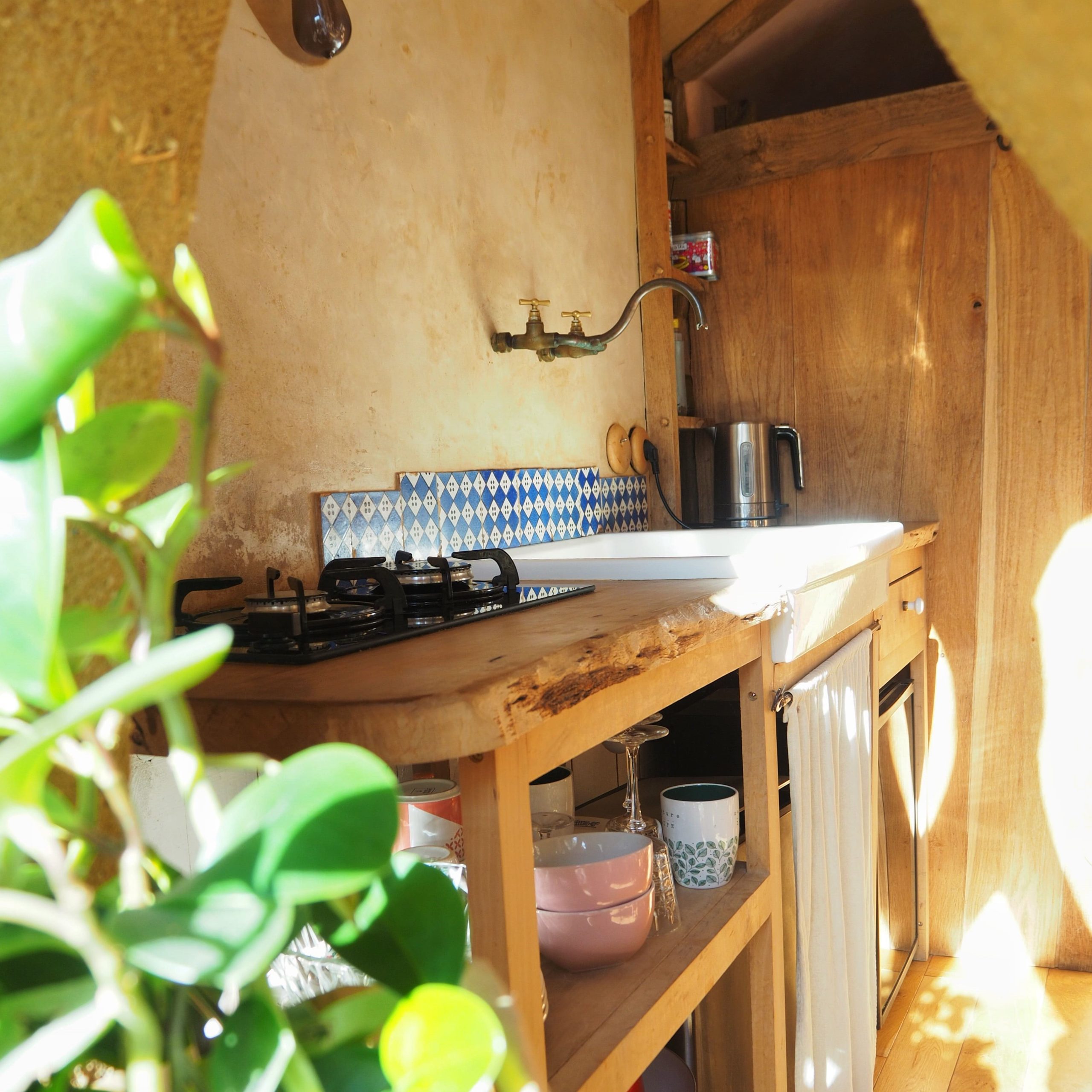 IMG_7249-carrén Hébergement insolite en Bretagne : cuisine en bois avec carrelage bleu et plantes vertes.