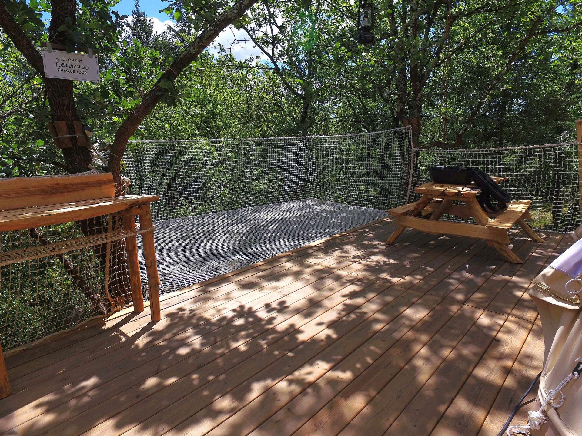 IMG_20210610_101518 Cabane perchée dans les arbres, avec terrasse en bois et vue sur la nature verdoyante.