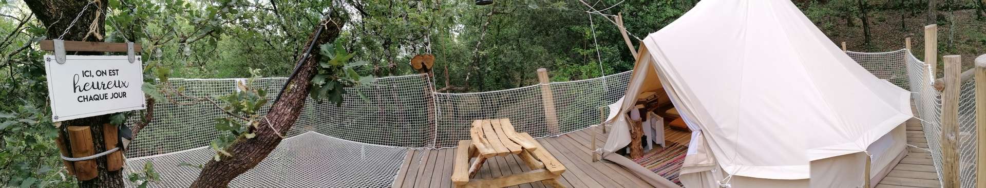 IMG_20210719_184626 Tente suspendue en pleine nature, entourée darbres et dune terrasse en bois.