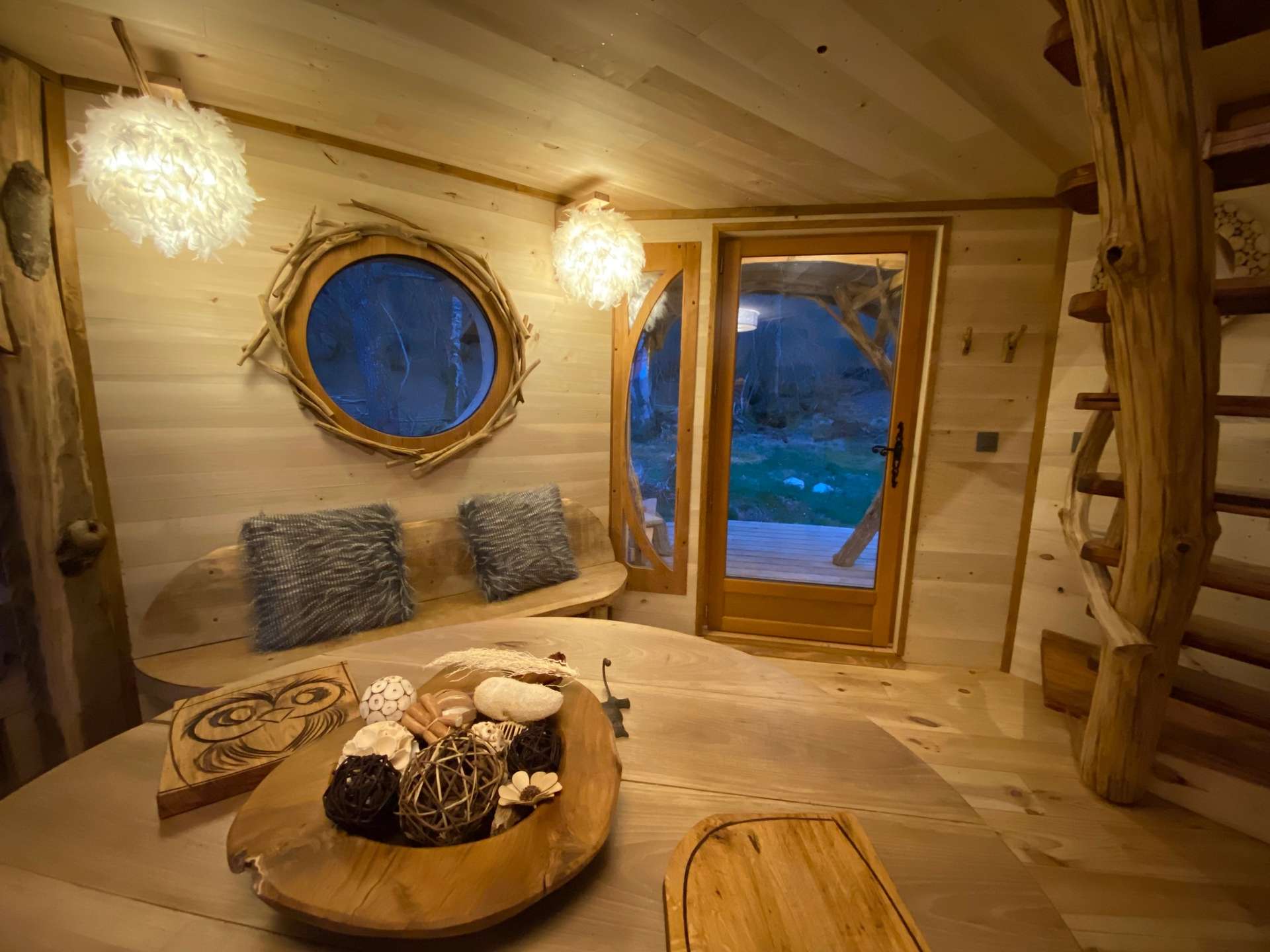 IMG_4598 Cabane en bois à Midi-Pyrénées, avec fenêtres rondes et décor naturel chaleureux.