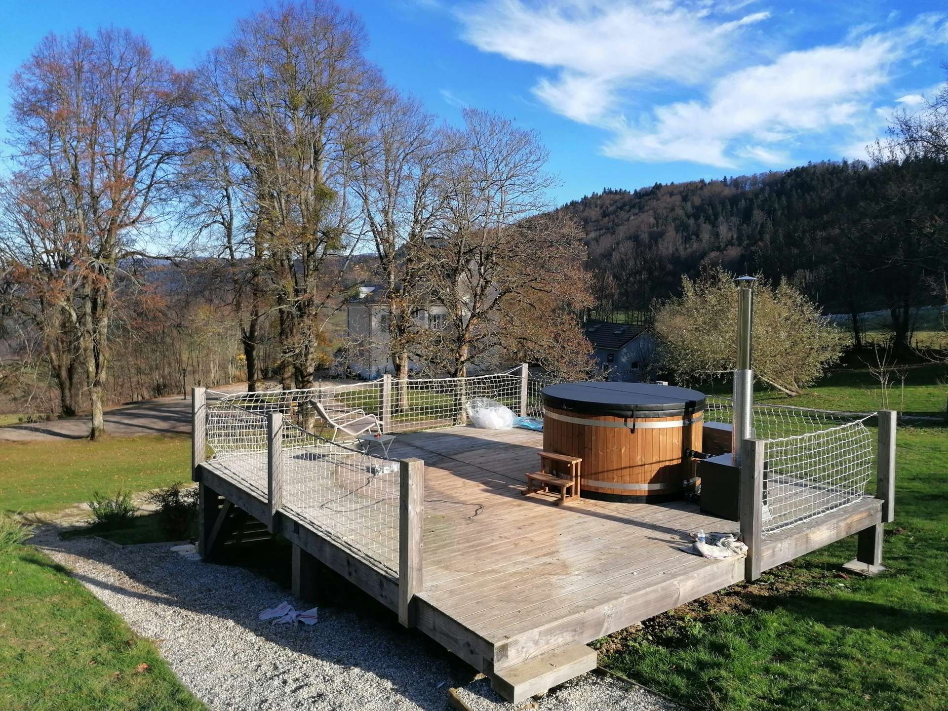 bain nordique Hébergement insolite en Auvergne-Rhône-Alpes avec terrasse et jacuzzi en bois.