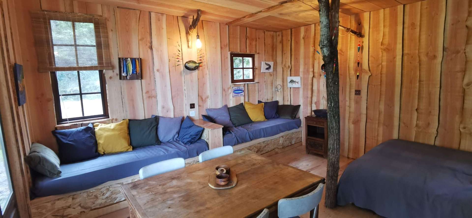 IMG_20210430_174437 Cabane en bois à Nouvelle-Aquitaine, intérieur chaleureux avec canapés colorés.