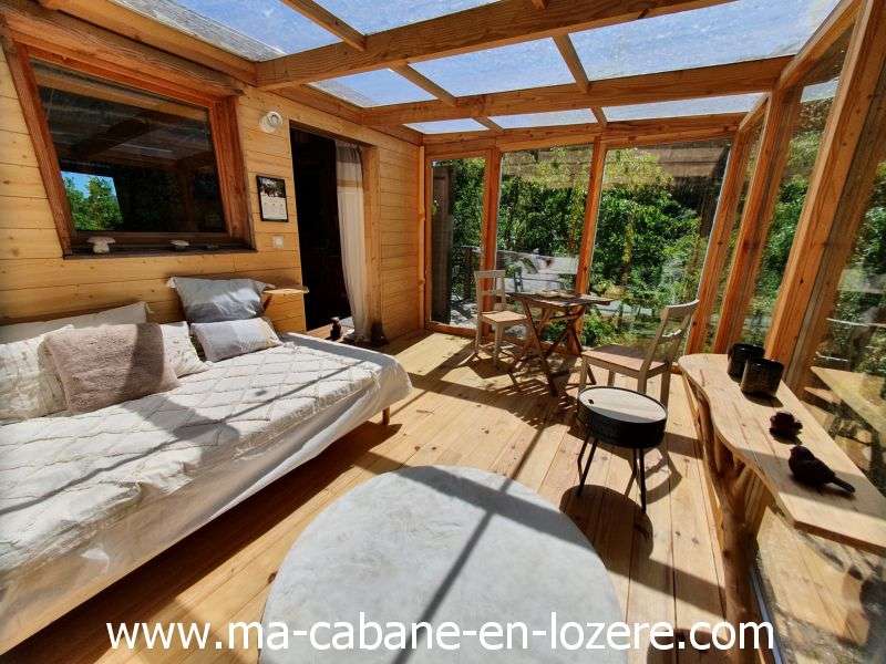 20220529_154723_resultat Cabane en bois lumineuse avec grandes baies vitrées et vue sur la nature.