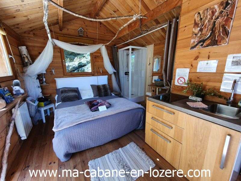 20220529_154804_resultat Cabane en bois cosy avec lit douillet et cuisine intégrée, au cœur de la nature.