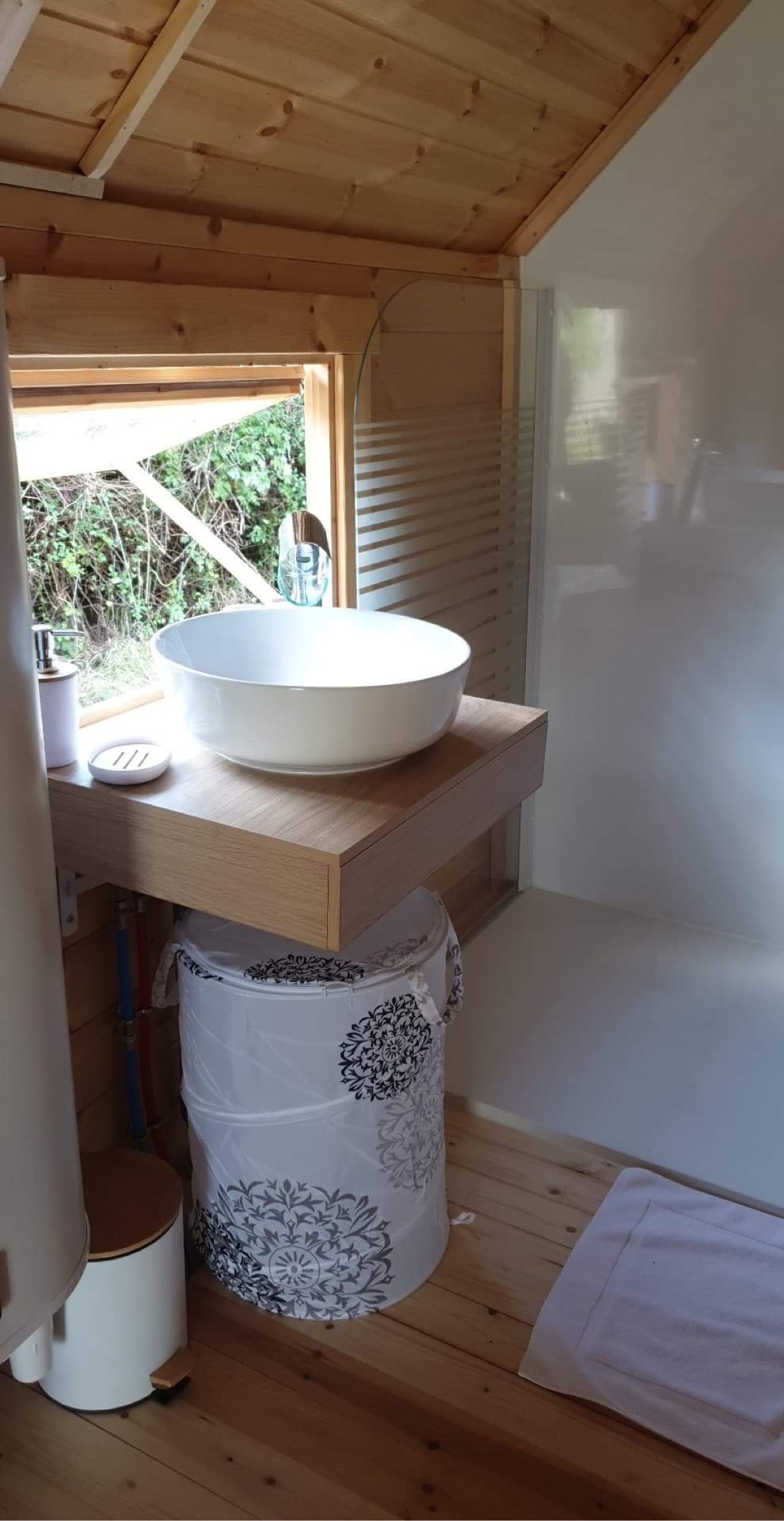 EE815155-7D13-4AA1-91B4-19A3D070FA7A Hébergement insolite en bois avec lavabo moderne et vue sur la nature.
