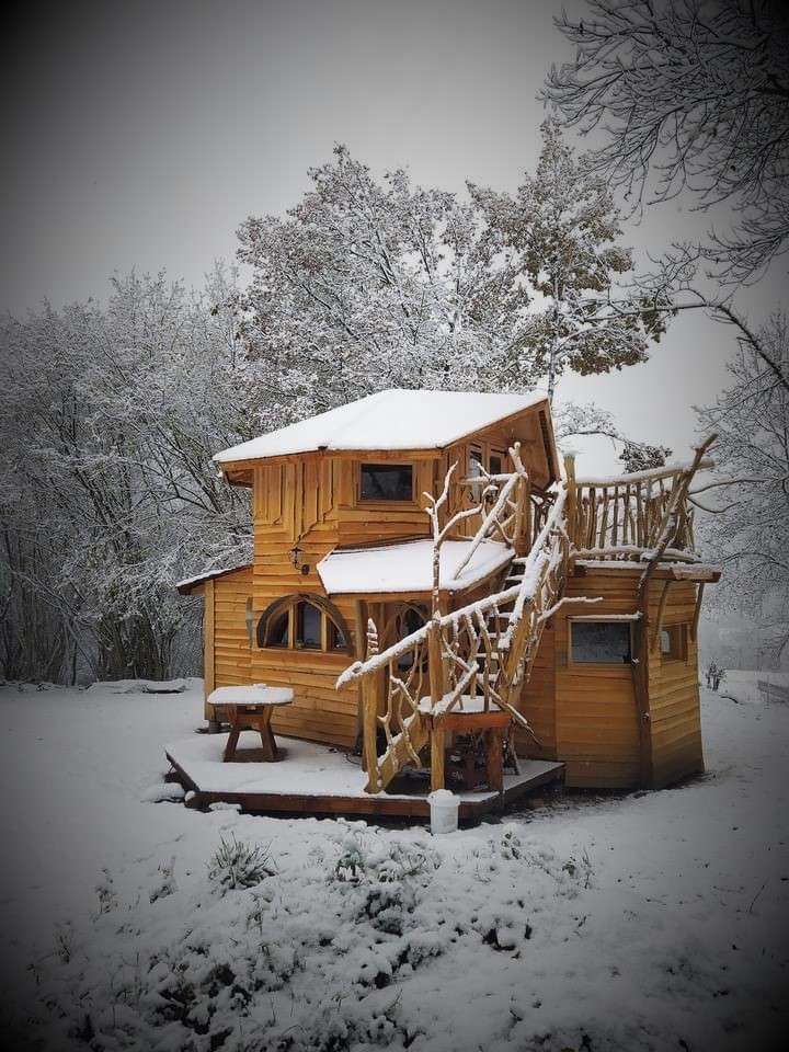 IMG_1393bis Cabane en bois perchée, entourée de neige et de nature paisible.