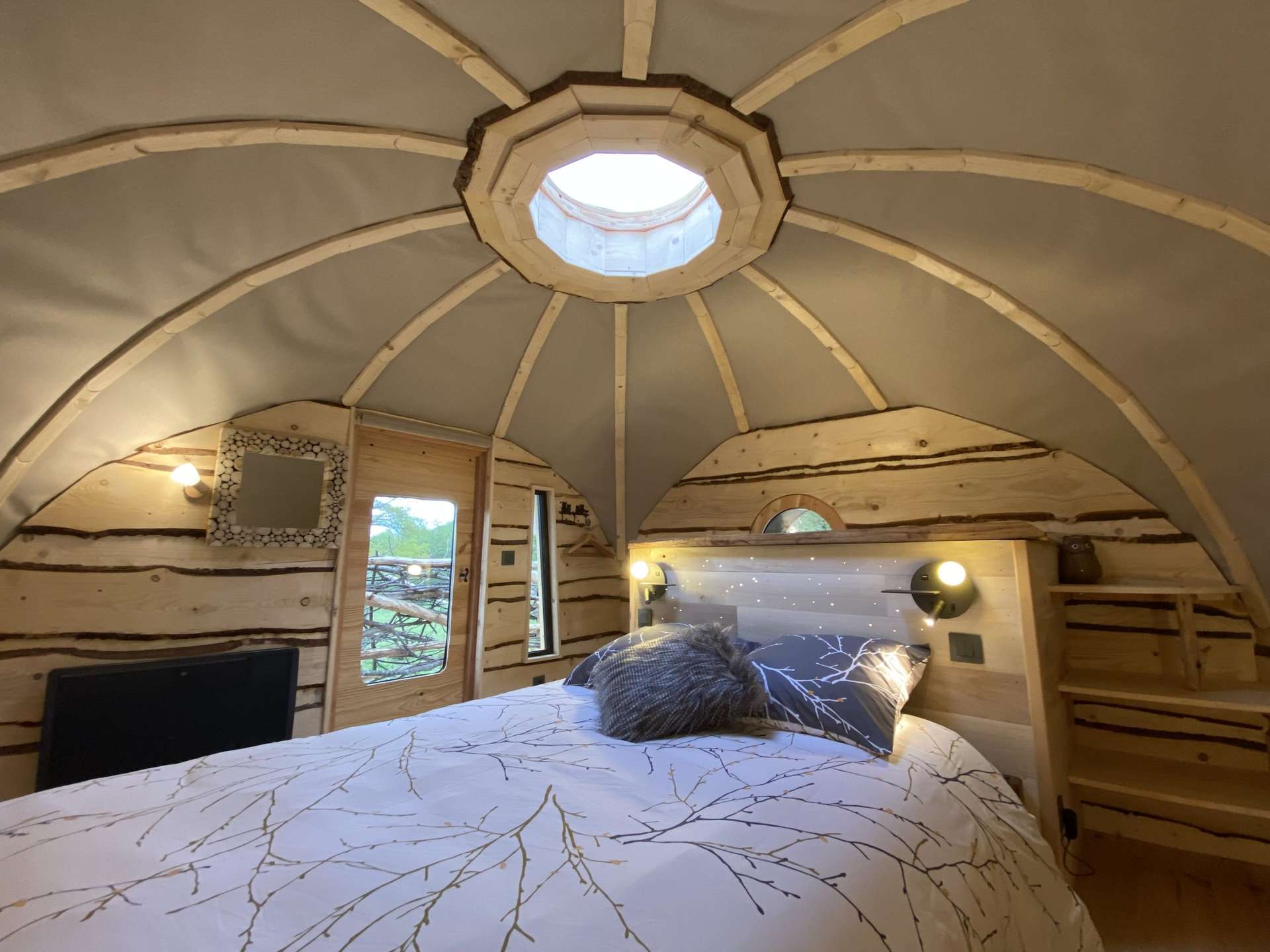 IMG_5434 Hébergement insolite en Midi-Pyrénées : cabane en bois avec un lit douillet et un puits de lumière.