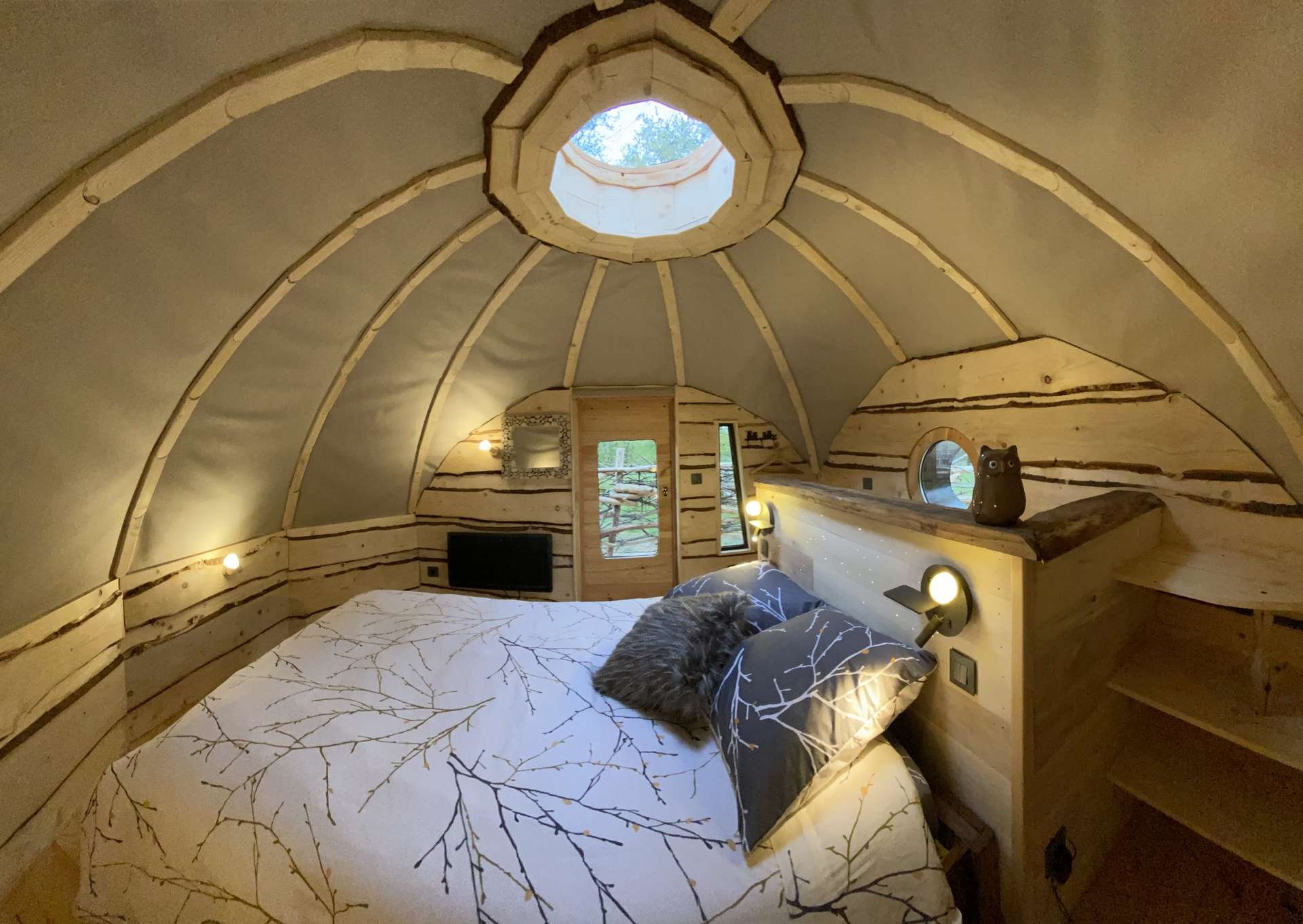 IMG_5447 Hébergement insolite en Midi-Pyrénées : cabane en bois avec un toit arrondi et fenêtre ronde.