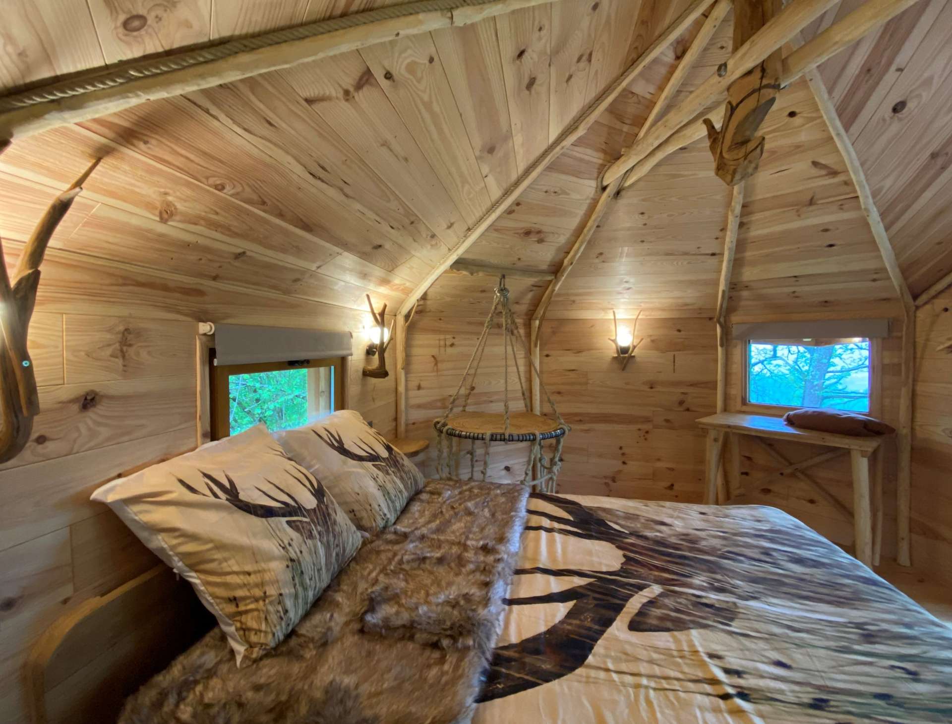 IMG_5592 Cabane en bois avec lit douillet et décor naturel, ambiance chaleureuse.