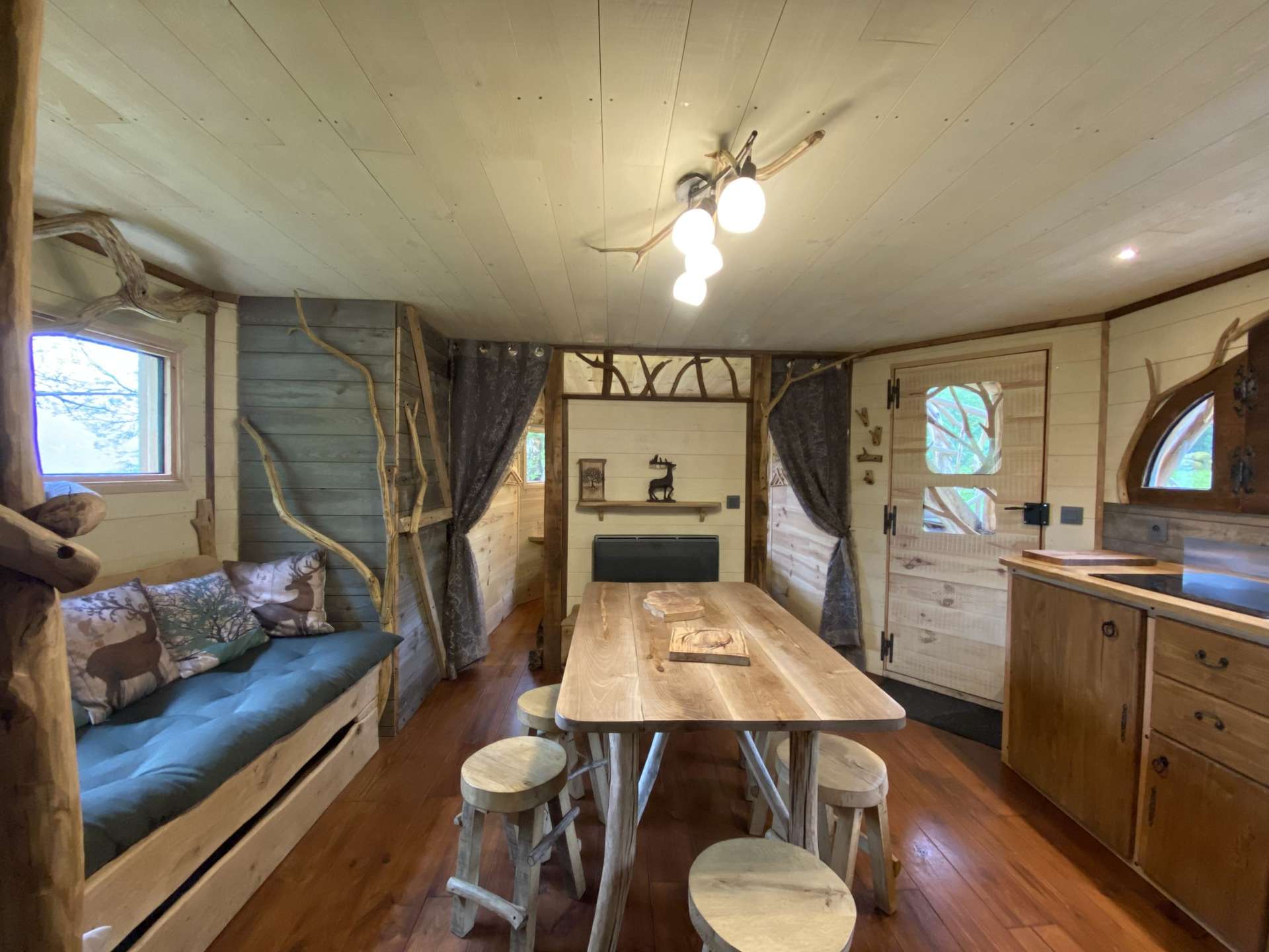 IMG_5692 Cabane en bois cosy avec un salon lumineux et une table en bois naturel.