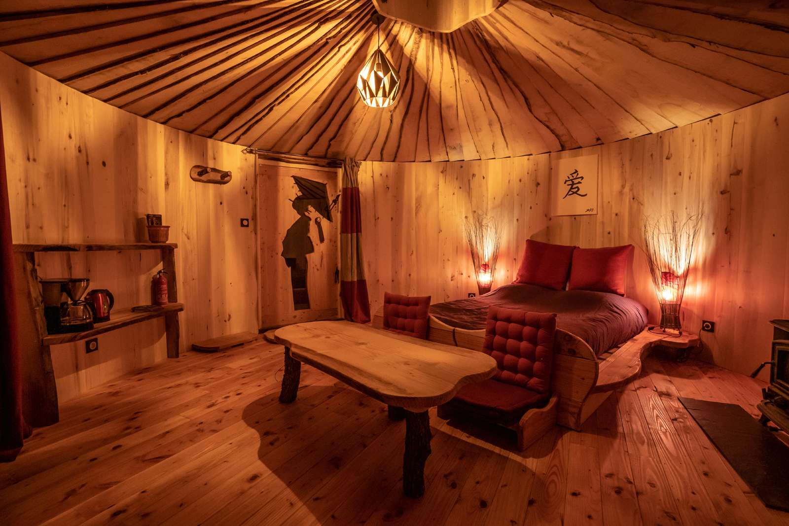 Hébergement insolite : yourte en bois avec lit douillet et ambiance chaleureuse.