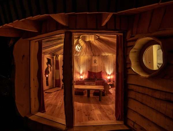 Hébergement insolite en yourte, intérieur chaleureux avec éclairage tamisé.