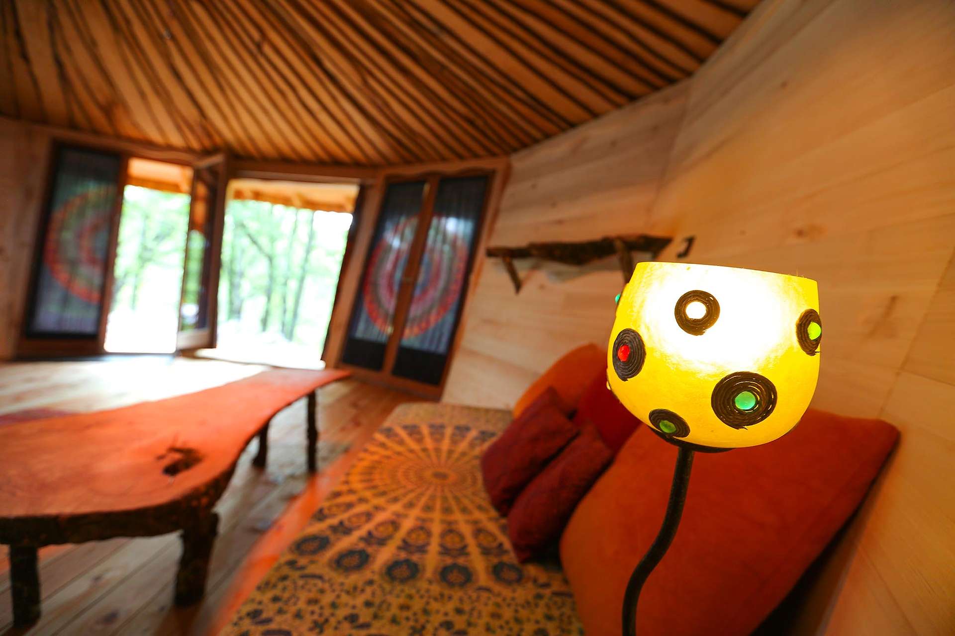couleurs-2 Hébergement insolite en yourte, intérieur chaleureux avec lampes colorées et bois naturel.