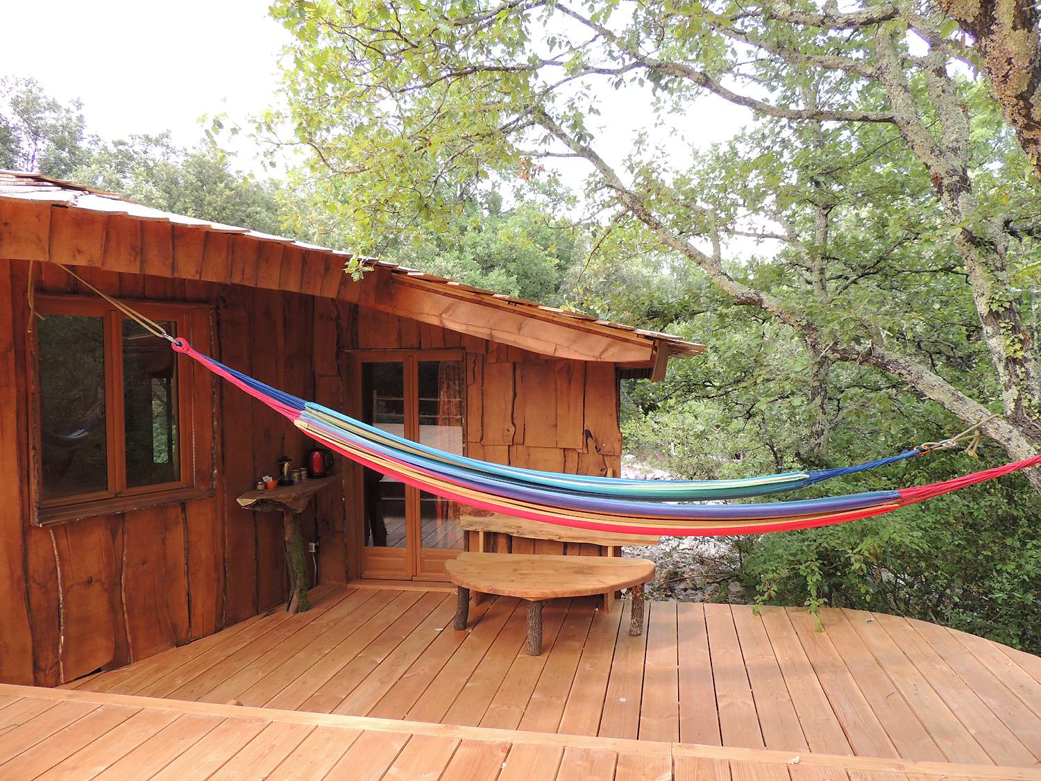 inattendue3 Cabane en bois dans le Languedoc-Roussillon, avec un hamac coloré suspendu.