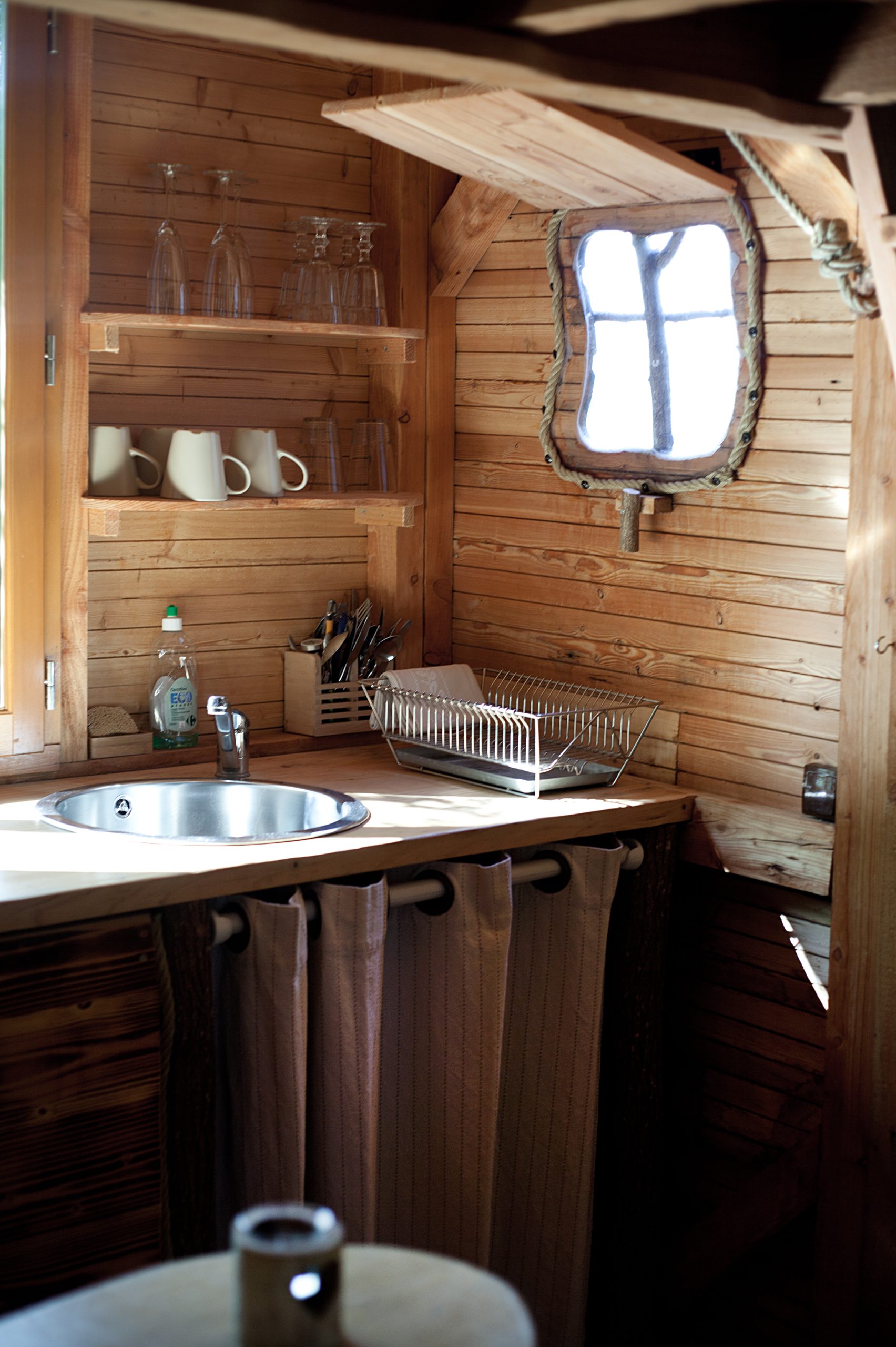 IMG_0663 Hébergement insolite en bois avec une cuisine cosy et un petit miroir vintage.