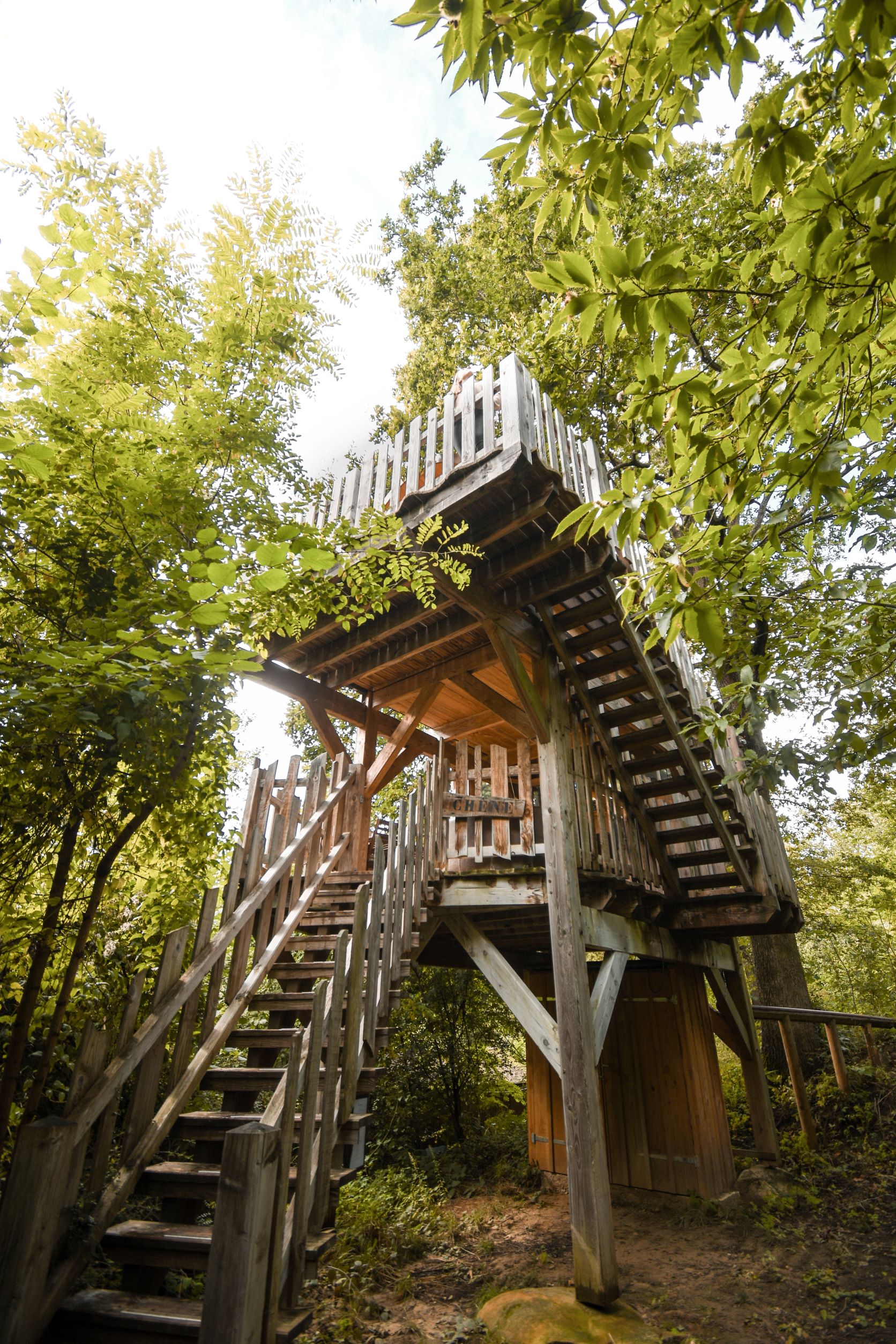 Cabane Chêne crédit - Jordan Sapally - Octobre 2021 Cabane perchée en bois, entourée de verdure, offrant une vue imprenable sur la nature.