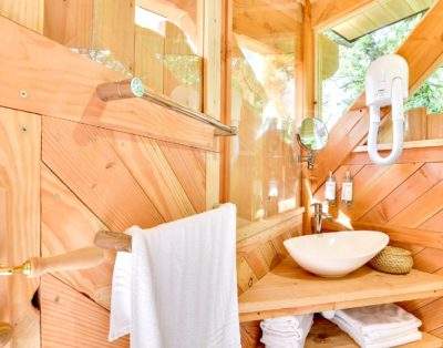 Cabane-spa-chene-salle-de-bain-bois-de-rosoy-400x314 Cabane en bois avec lavabo design et lumière naturelle abondante.