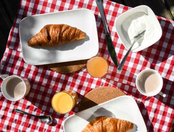 Petit-déjeuner en pleine nature dans un hébergement insolite, avec croissants et jus.