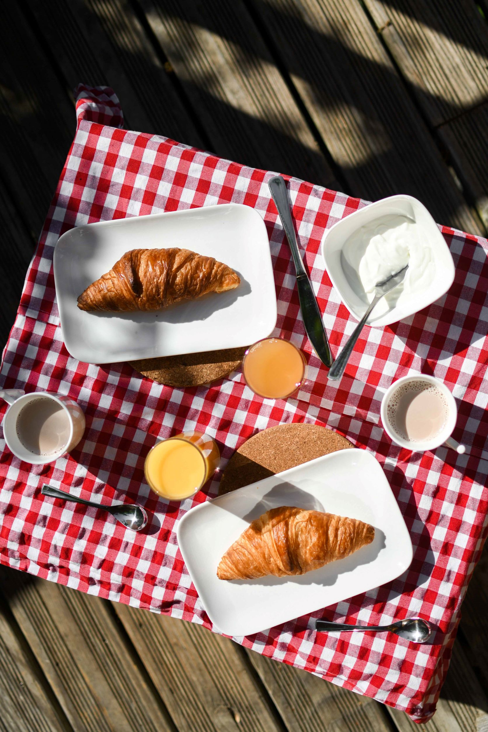 Petit-déjeuner en pleine nature dans un hébergement insolite, avec croissants et jus.