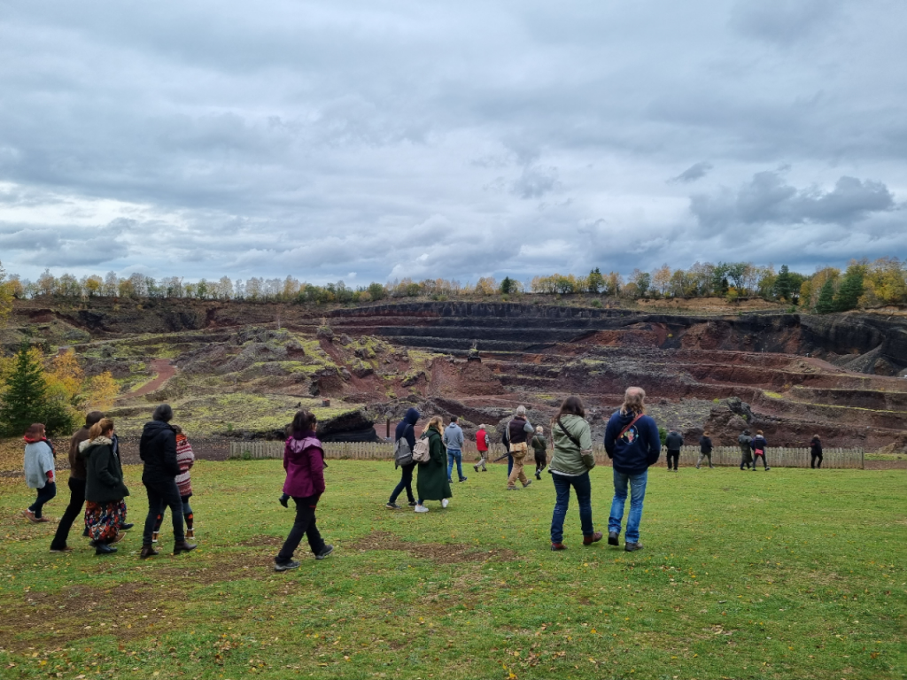 Groupe de visiteurs explorant un site naturel avec des formations géologiques impressionnantes.