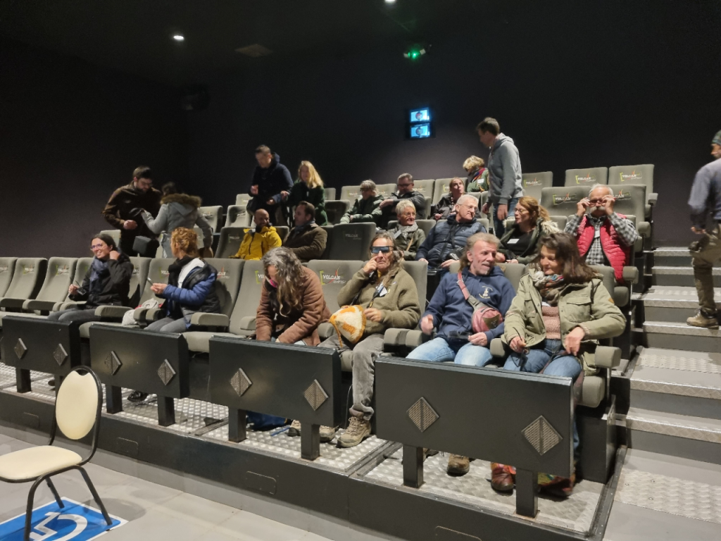 Salle de cinéma moderne avec des sièges confortables et un public attentif.