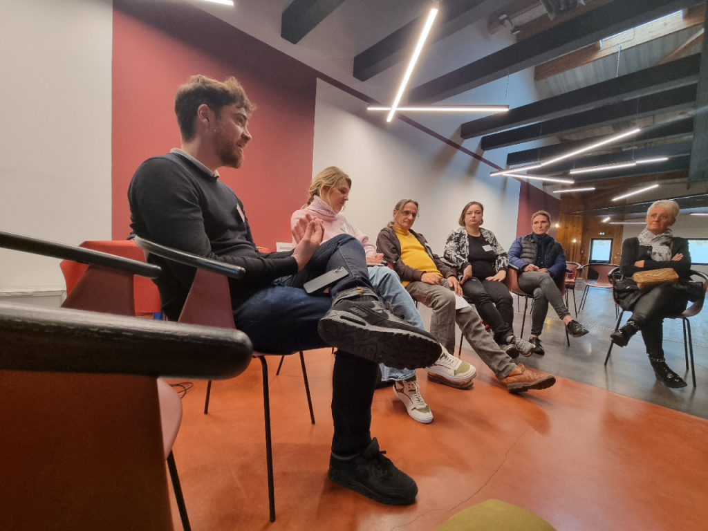 Séminaire dans un espace de coworking moderne, participants attentifs autour dune table.