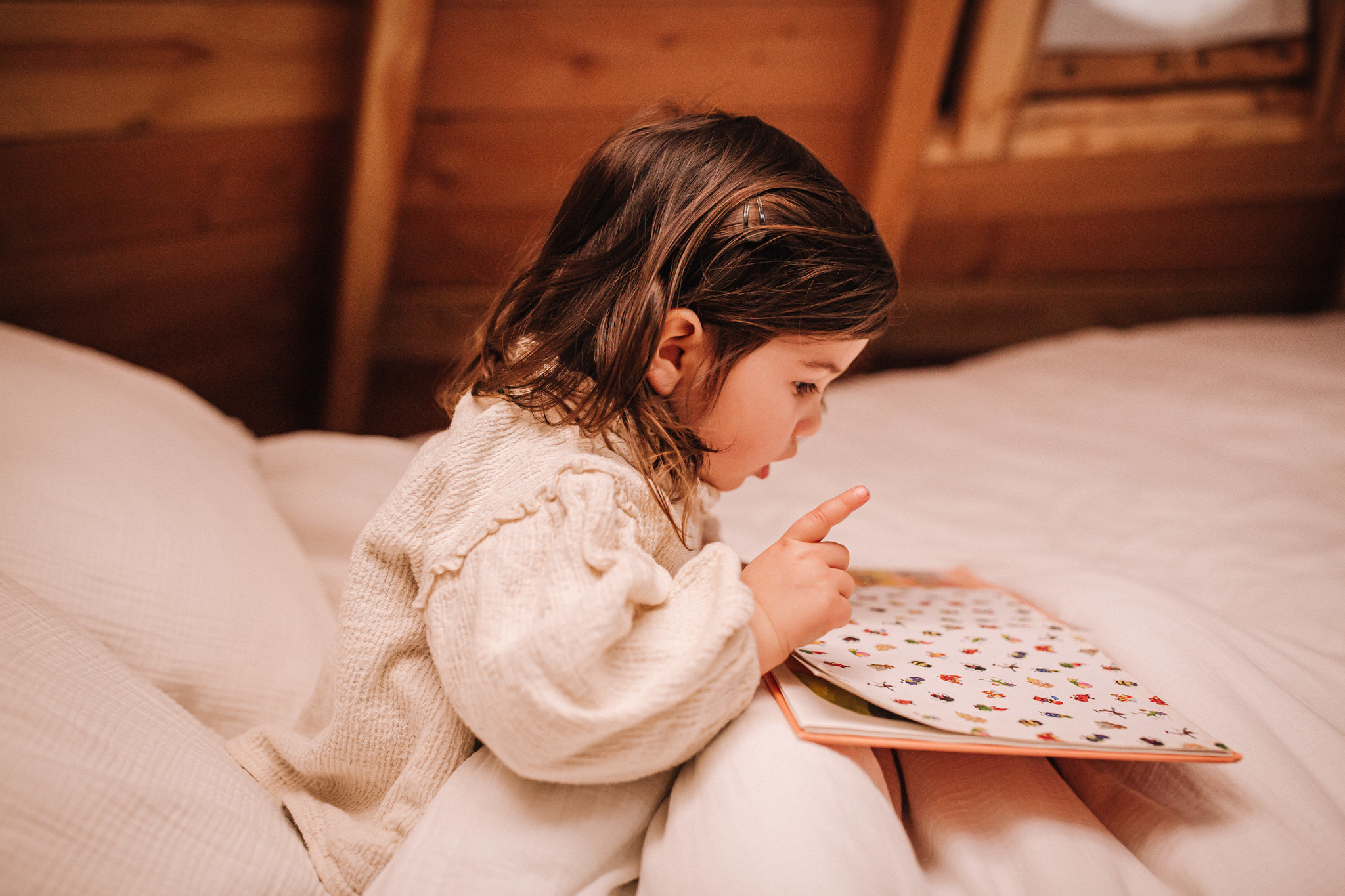Entreprise_ChouetteCabane_JustineB-116 Enfant lisant dans un chalet en bois, hébergement insolite en Pays de la Loire.