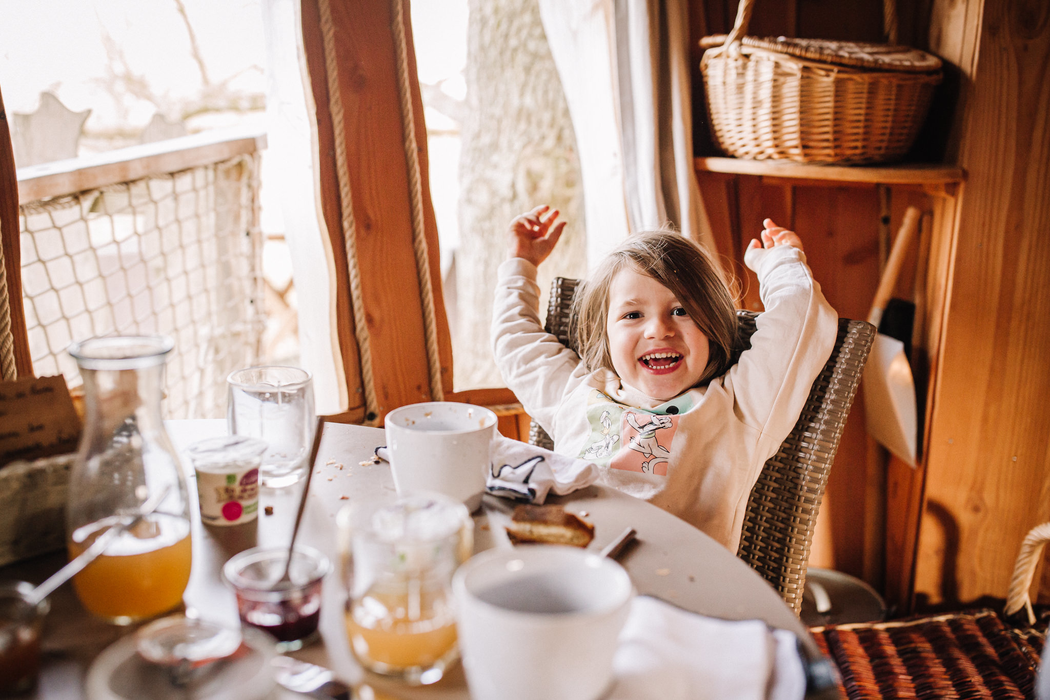 Entreprise_ChouetteCabane_JustineB-161 Cabane perchée en Pays de la Loire, enfant joyeux à table avec vue sur la nature.