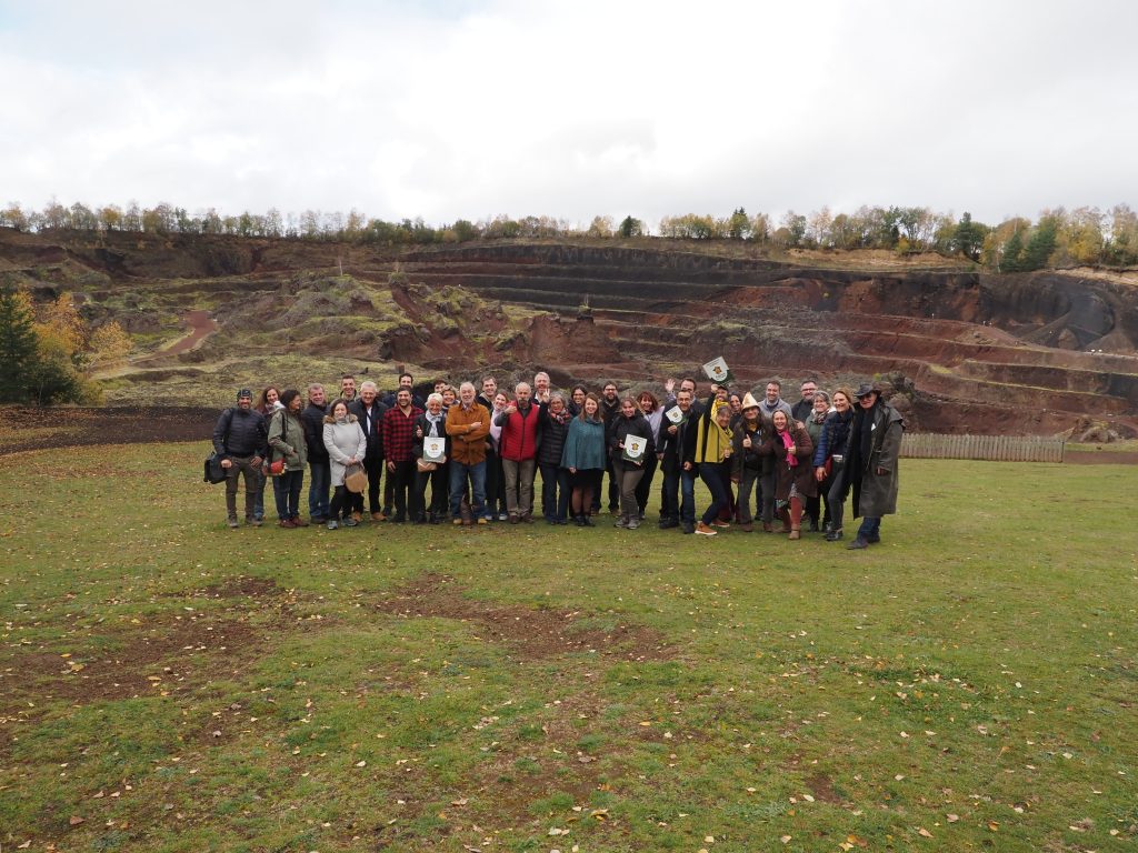 Groupe de visiteurs devant un hébergement en pleine nature, avec des paysages de carrière.