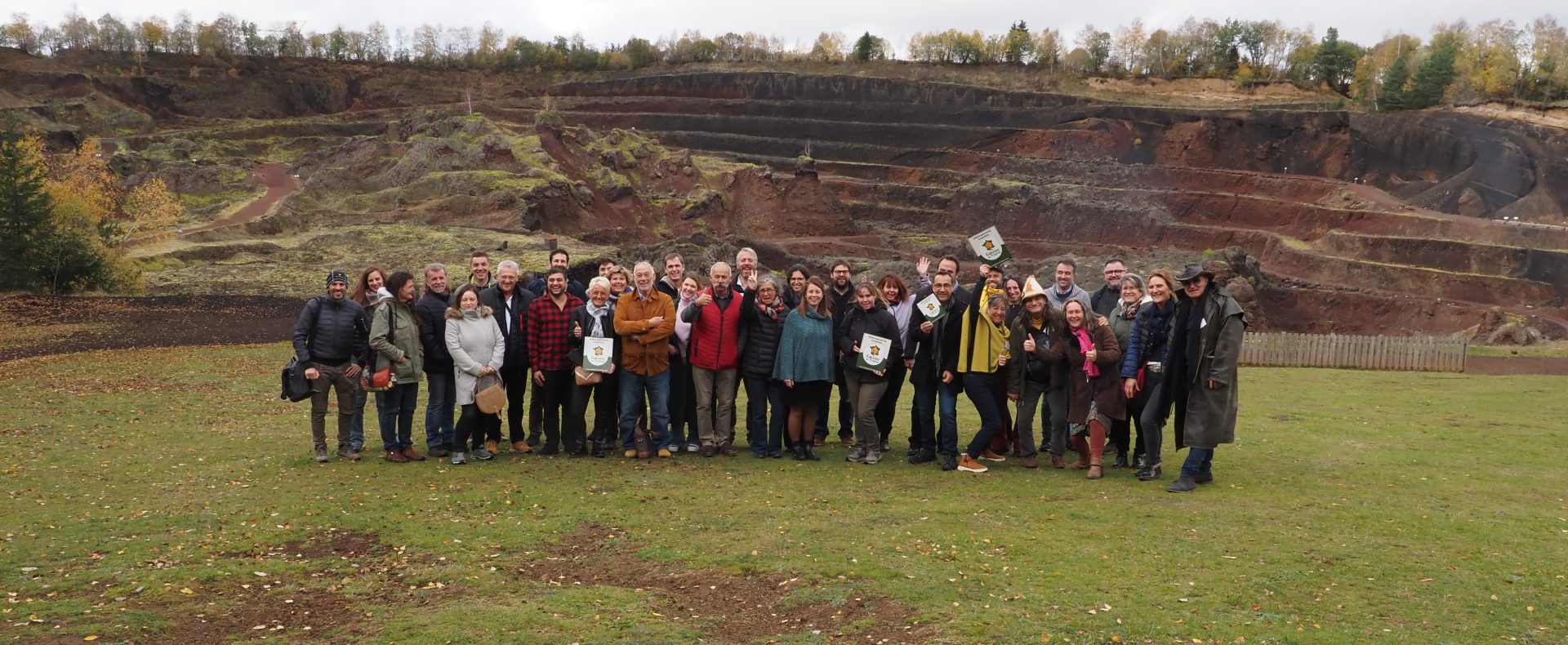 Groupe de visiteurs devant un hébergement en pleine nature, avec des paysages de carrière.