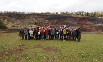 Groupe de visiteurs devant un hébergement en pleine nature, avec des paysages de carrière.