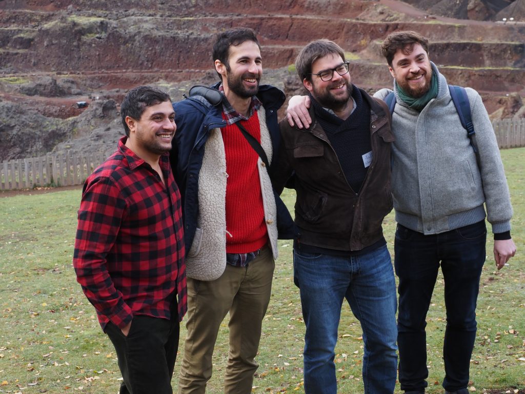 Groupe damis devant un hébergement en pleine nature, entouré de paysages montagneux.