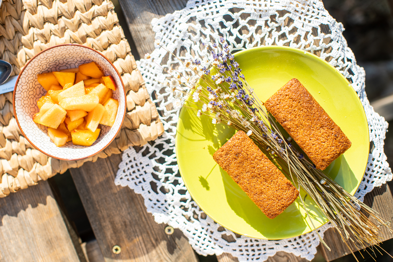 065A1558 Dégustation gourmande dans un hébergement insolite : gâteaux sur assiette verte et fruits.